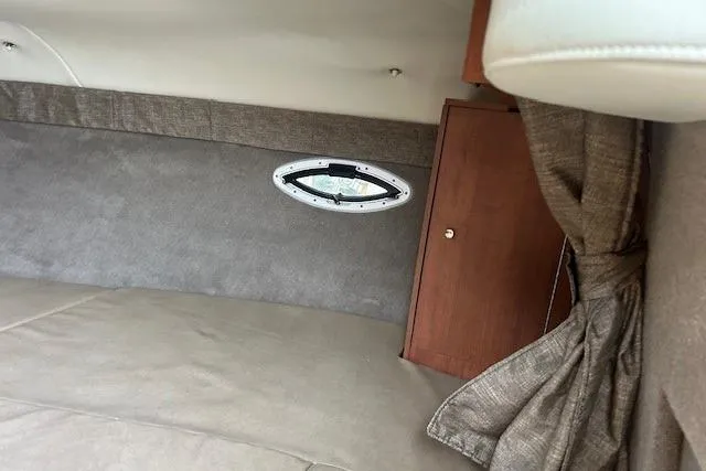 Slide: The Image of 2017 Stingray 250 CR cabin interior with porthole and wooden cabinet. - 18