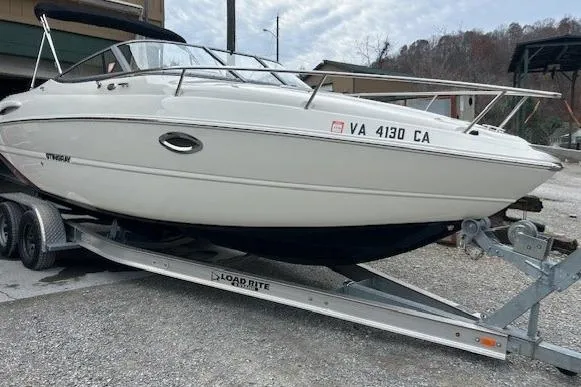 Slide: The Image of 2017 Stingray 250 CR boat on trailer, parked outdoors. - 2