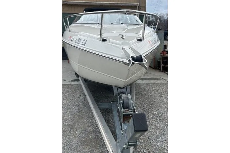 Slide: The Image of 2017 Stingray 250 CR boat on trailer, front view, parked outdoors. - 4
