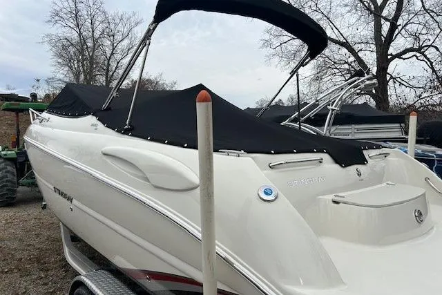 Slide: The Image of 2017 Stingray 250 CR boat with black cover on trailer, parked outdoors. - 6