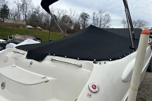 Slide: The Image of 2017 Stingray 250 CR boat with black cover, parked outdoors. - 7