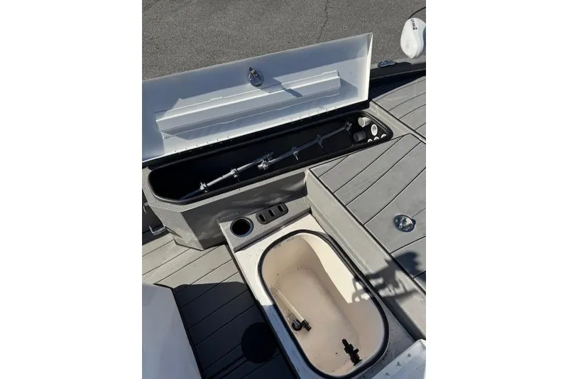 Slide: The Image of 2023 Vexus AVX1980CC boat interior with open storage compartments and fishing rod holders. - 13