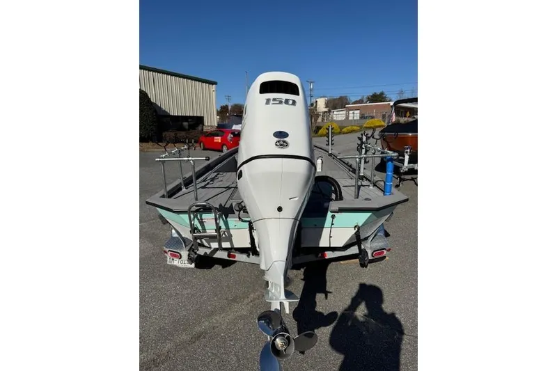 Slide: The Image of 2023 Vexus AVX1980CC boat with 150 HP engine, parked outdoors on a sunny day. - 5
