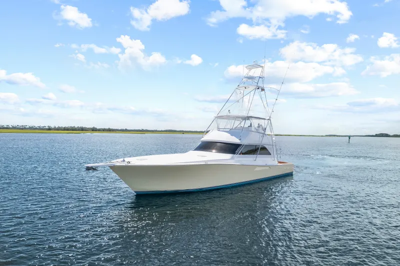 Slide: The Image of 2005 Viking 61 Convertible yacht cruising on calm waters under a blue sky. - 1