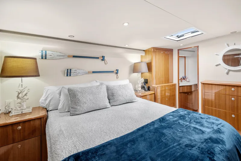 Slide: The Image of Luxurious 2005 Viking 61 Convertible yacht bedroom with nautical decor and elegant wood finishes. - 19