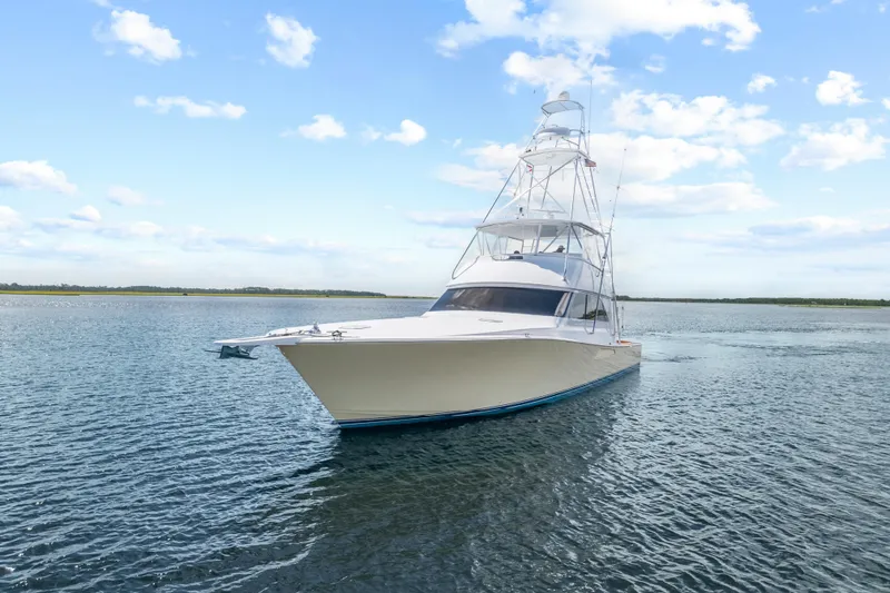 Slide: The Image of 2005 Viking 61 Convertible yacht cruising on calm waters under a clear blue sky. - 2