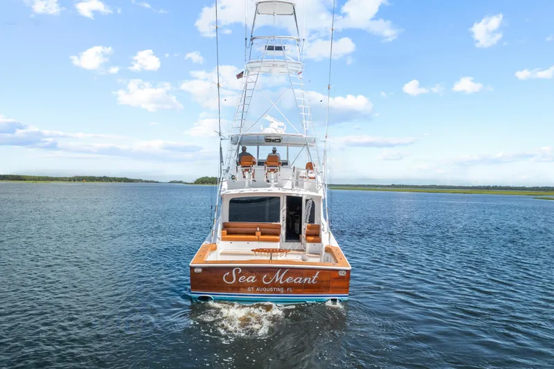 Slide: The Image of 2005 Viking 61 Convertible yacht cruising on open water under a clear blue sky. - 26