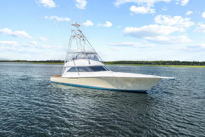 Slide: The Image of 2005 Viking 61 Convertible yacht on calm water under blue sky. - 4