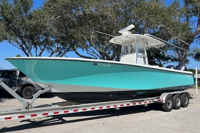 The Image of 2008 Contender 31 Fisharound boat on trailer, parked outdoors under trees. - 0