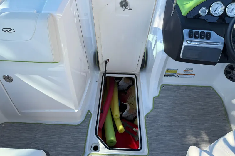 Slide: The Image of 2018 Regal 22 FasDeck boat interior with storage compartment and pool noodles. - 13