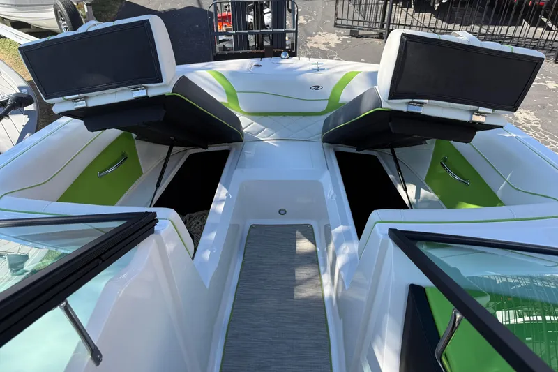Slide: The Image of 2018 Regal 22 FasDeck boat interior with green accents and open storage compartments. - 14