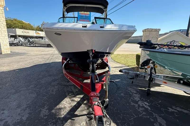 Slide: The Image of 2018 Regal 22 FasDeck boat on a red trailer, parked outdoors. - 2