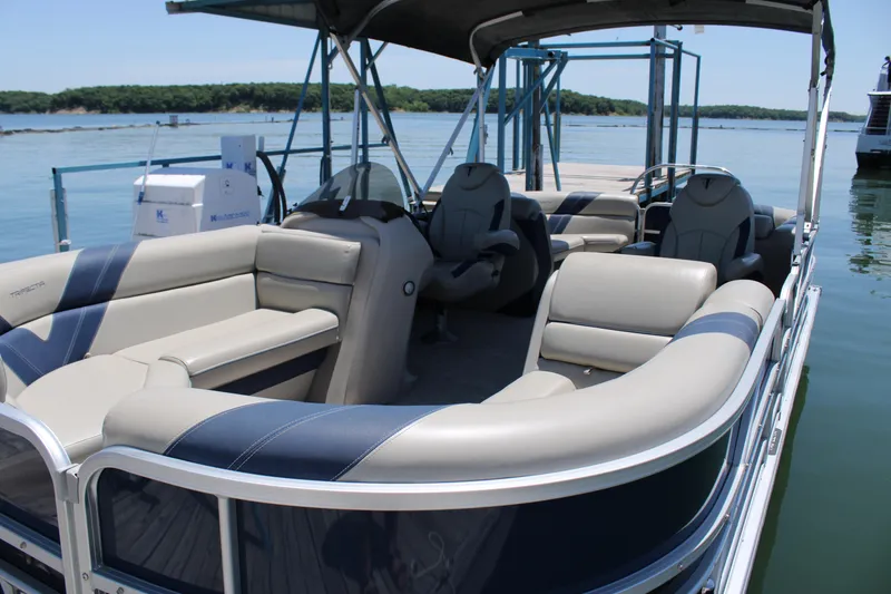 Slide: The Image of 2022 Trifecta RFLE pontoon boat with spacious seating, docked on a serene lake. - 5