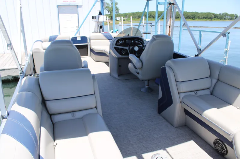 Slide: The Image of 2022 Trifecta RFLE pontoon boat interior with plush seating and steering console. - 6