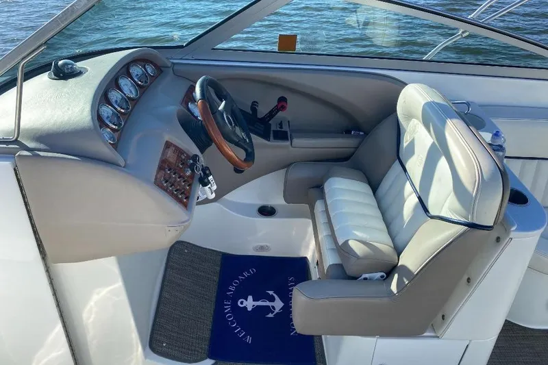 Slide: The Image of 2002 Cobalt 282 boat cockpit with steering wheel, gauges, and cushioned seat. - 11
