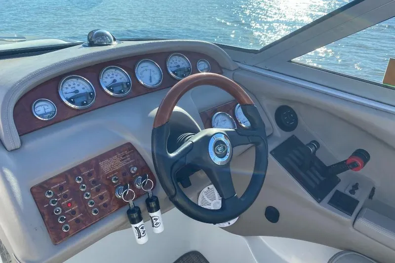 Slide: The Image of Dashboard of a 2002 Cobalt 282 boat with gauges and steering wheel. - 12