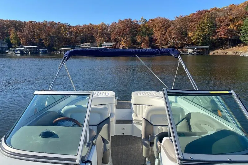 Slide: The Image of 2002 Cobalt 282 boat on a serene lake with autumn foliage in the background. - 16