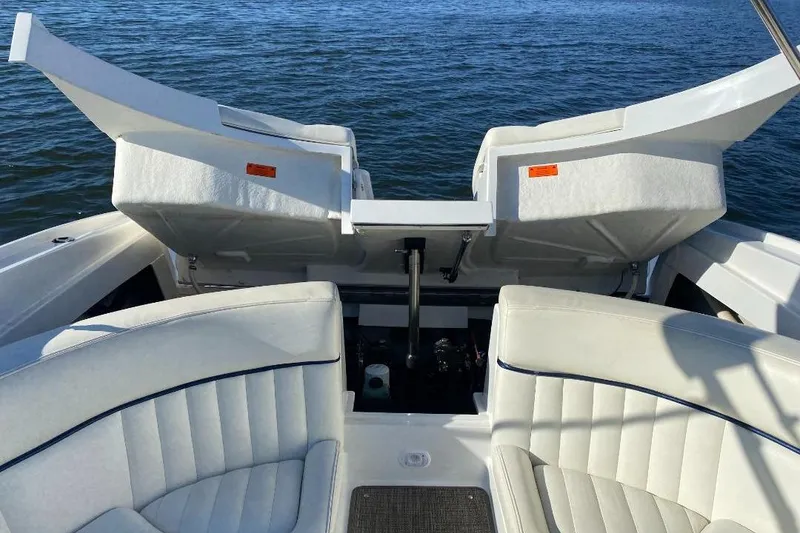Slide: The Image of 2002 Cobalt 282 boat interior with white seating and open storage compartments on water. - 18