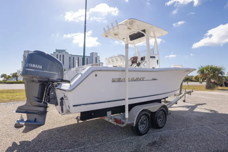 Slide: The Image of 2012 Sea Hunt Ultra 225 boat on trailer with Yamaha outboard motor, parked outdoors. - 13