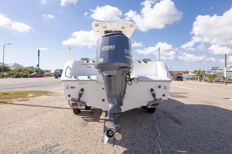 Slide: The Image of 2012 Sea Hunt Ultra 225 boat with Yamaha 200 engine, parked outdoors under blue sky. - 14