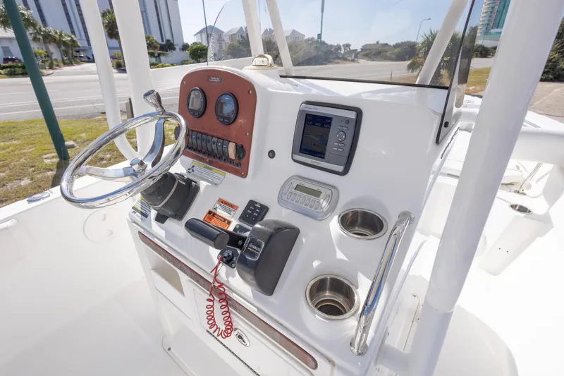 Slide: The Image of 2012 Sea Hunt Ultra 225 boat console with steering wheel and navigation instruments. - 17
