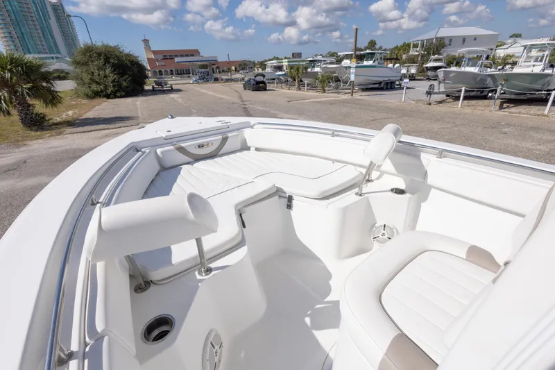 Slide: The Image of 2012 Sea Hunt Ultra 225 boat with white seating, parked outdoors under a blue sky. - 18