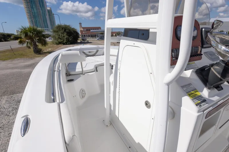 Slide: The Image of 2012 Sea Hunt Ultra 225 boat interior with console and seating, under clear blue sky. - 24
