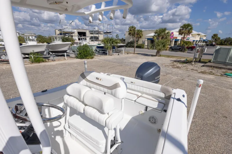 Slide: The Image of 2012 Sea Hunt Ultra 225 boat interior with Yamaha engine, parked outdoors under a cloudy sky. - 25