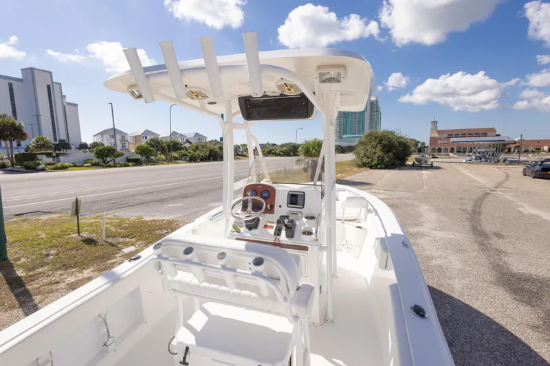 Slide: The Image of 2012 Sea Hunt Ultra 225 boat parked near a coastal road under a blue sky. - 29