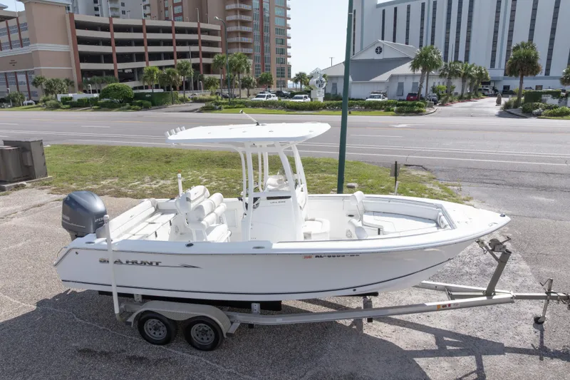 Slide: The Image of 2012 Sea Hunt Ultra 225 boat on trailer, parked near urban buildings. - 8