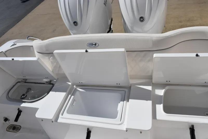 Slide: The Image of 2026 Sea Hunt Ultra 265 SE boat with open storage compartments and dual engines. - 17