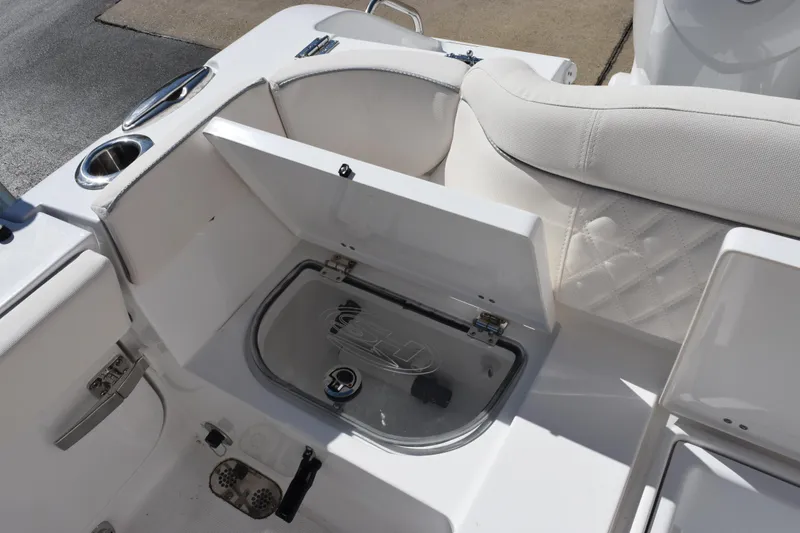 Slide: The Image of 2026 Sea Hunt Ultra 265 SE boat interior with open storage compartment and cup holder. - 18