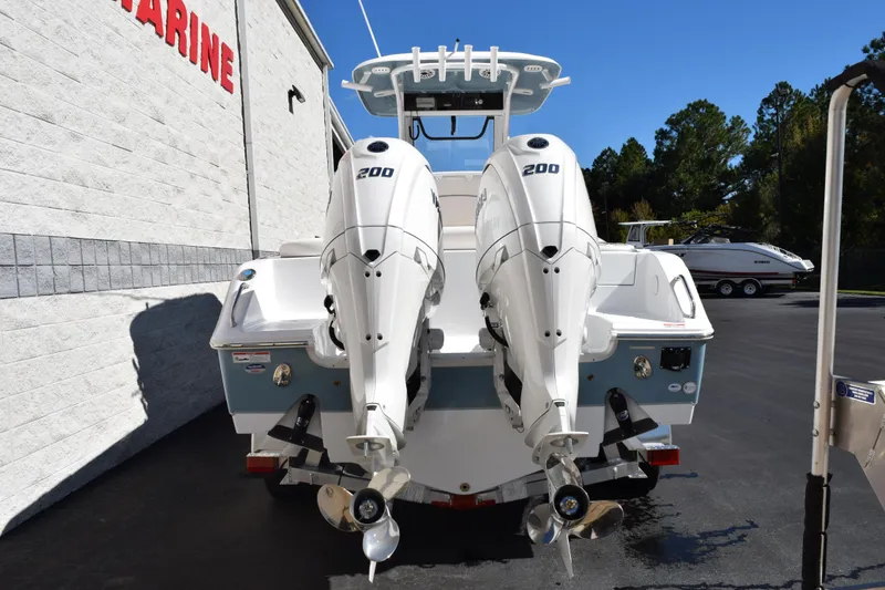 Slide: The Image of 2026 Sea Hunt Ultra 265 SE boat with dual 200 horsepower engines, parked outdoors. - 5