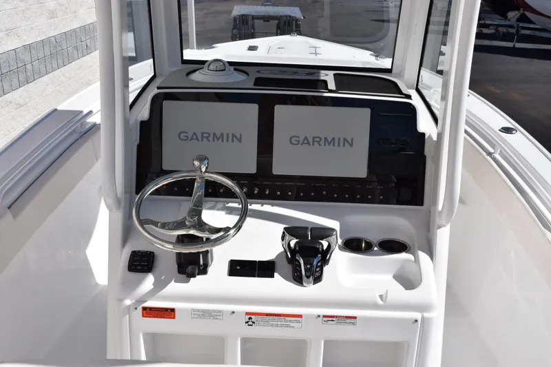 Slide: The Image of 2026 Sea Hunt Ultra 265 SE boat dashboard with Garmin displays and steering wheel. - 9