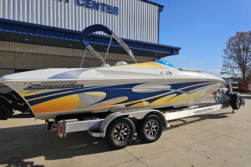 Slide: The Image of 2010 Sunsation 288 MID-CABIN boat on trailer, vibrant design, parked outside a building. - 11