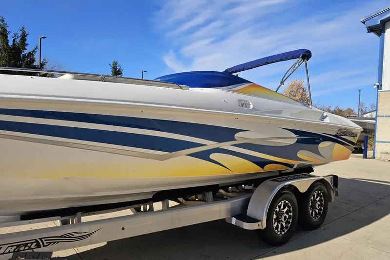 Slide: The Image of 2010 Sunsation 288 MID-CABIN - OPEN BOW boat on trailer, vibrant blue and yellow design. - 21