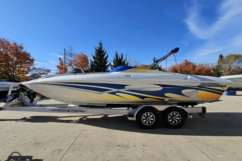 Slide: The Image of 2010 Sunsation 288 MID-CABIN boat on trailer, vibrant graphics, autumn trees in background. - 24