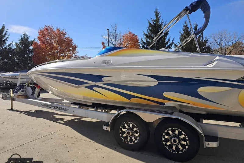 Slide: The Image of 2010 Sunsation 288 MID-CABIN boat on trailer, vibrant graphics, autumn trees in background. - 26