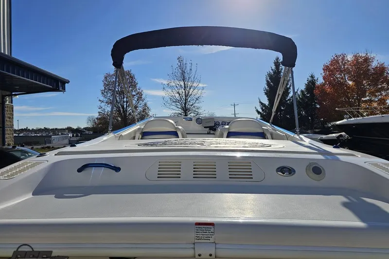 Slide: The Image of 2010 Sunsation 288 MID-CABIN OPEN BOW boat with canopy, parked outdoors under clear sky. - 33
