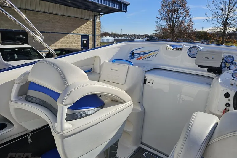 Slide: The Image of 2010 Sunsation 288 MID-CABIN boat interior with white and blue seating, dashboard, and Garmin device. - 58