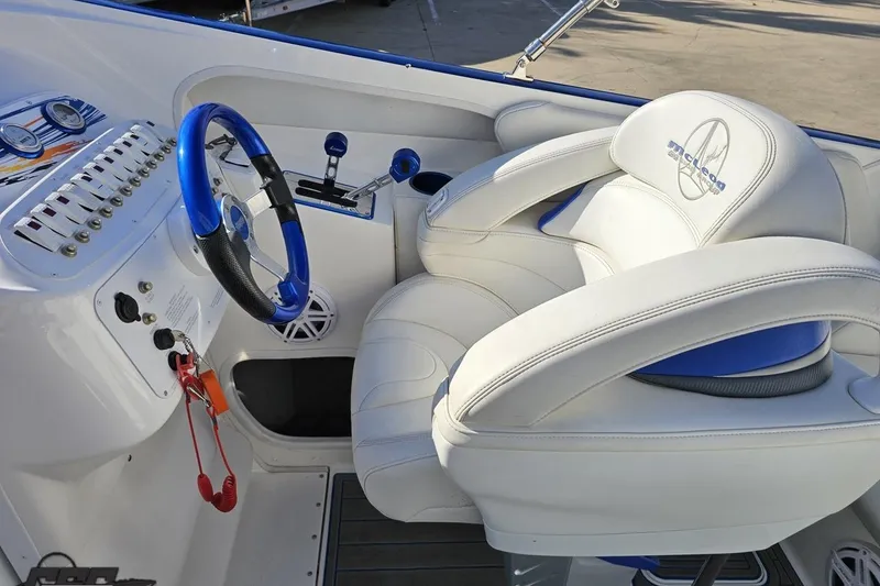 Slide: The Image of 2010 Sunsation 288 MID-CABIN boat cockpit with blue steering wheel and white seating. - 61