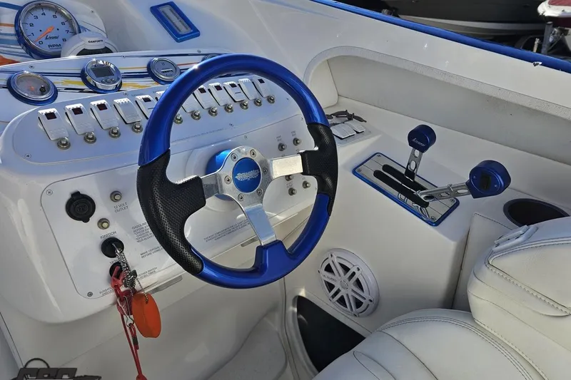 Slide: The Image of 2010 Sunsation 288 MID-CABIN boat cockpit with blue steering wheel and control panel. - 62