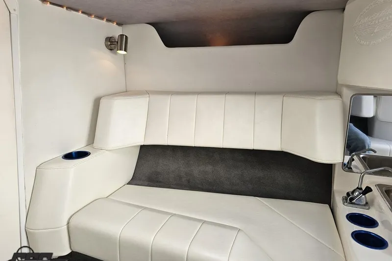Slide: The Image of 2010 Sunsation 288 MID-CABIN interior with white seating, cup holders, and modern lighting. - 77