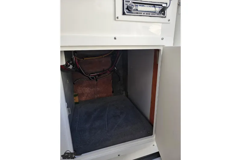 Slide: The Image of 2010 Sunsation 288 MID-CABIN interior storage compartment with wiring and stereo system. - 80