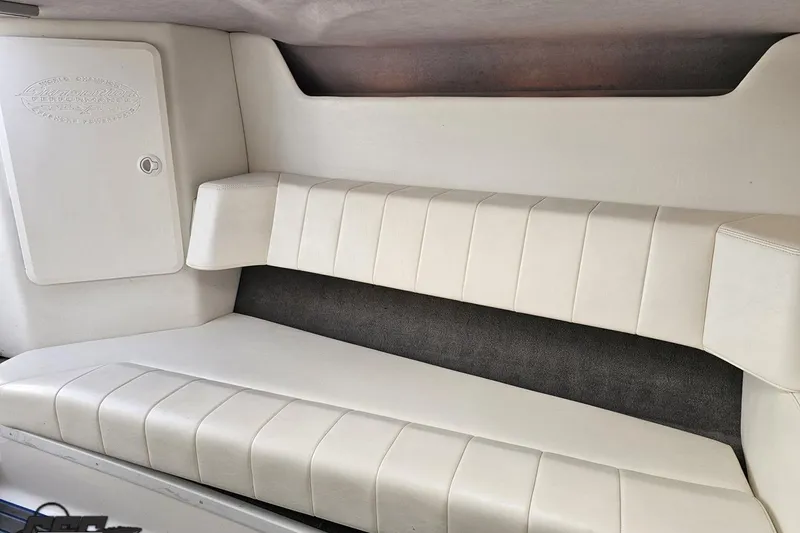 Slide: The Image of 2010 Sunsation 288 MID-CABIN interior with white cushioned seating and storage compartment. - 83