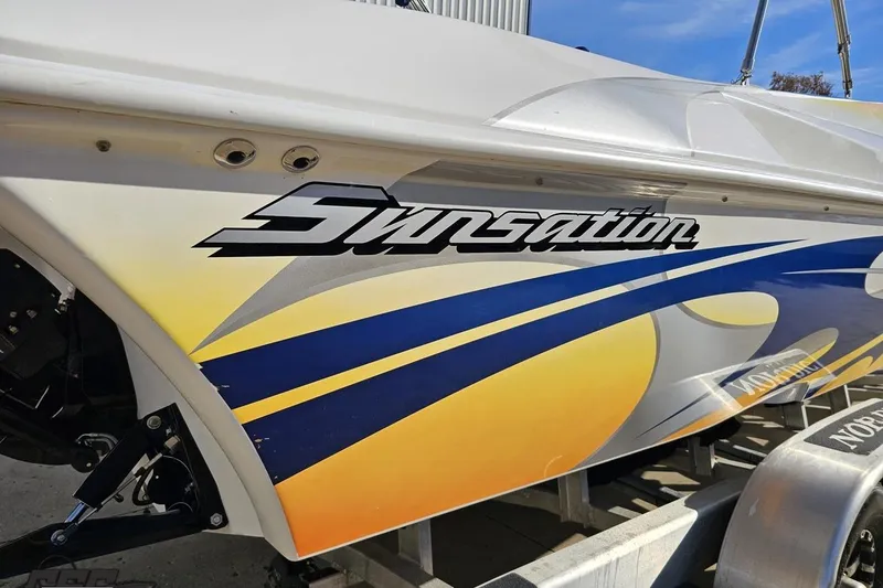 Slide: The Image of 2010 Sunsation 288 MID-CABIN - OPEN BOW boat with vibrant graphics on trailer. - 9