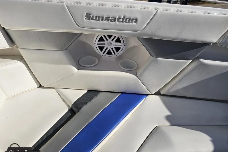 Slide: The Image of 2010 Sunsation 288 MID-CABIN boat interior with white and blue seating, speaker, and cup holders. - 92
