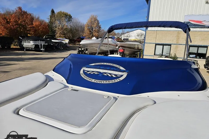 Slide: The Image of 2010 Sunsation 288 MID-CABIN - OPEN BOW boat with blue cover in a marina setting. - 93