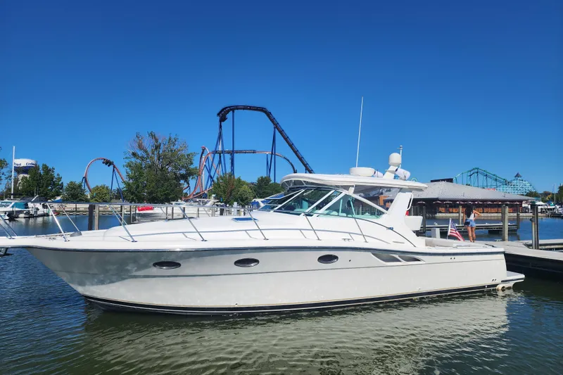 Slide: The Image of 2001 Tiara Yachts 3500 Open docked near amusement park rides under clear blue sky. - 1