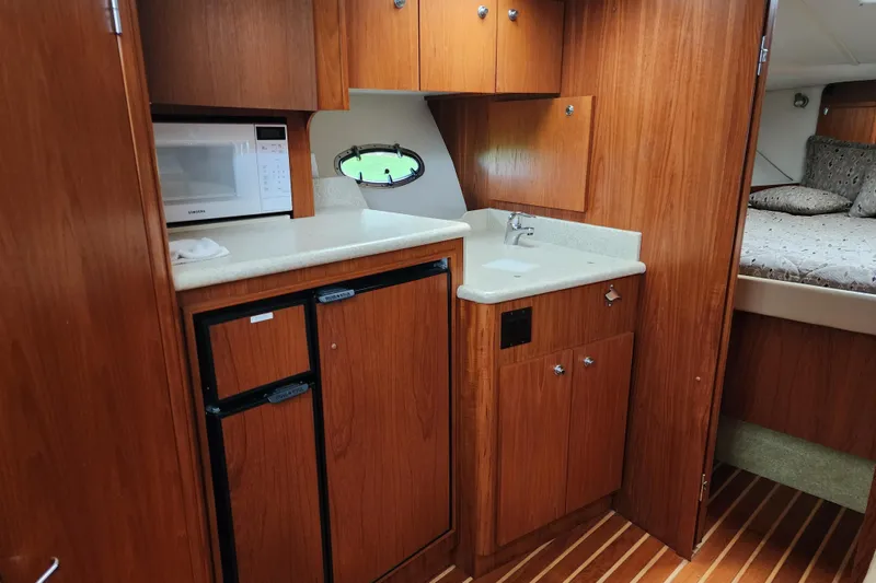 Slide: The Image of 2001 Tiara Yachts 3500 Open interior with kitchenette, microwave, and wood cabinetry. - 10